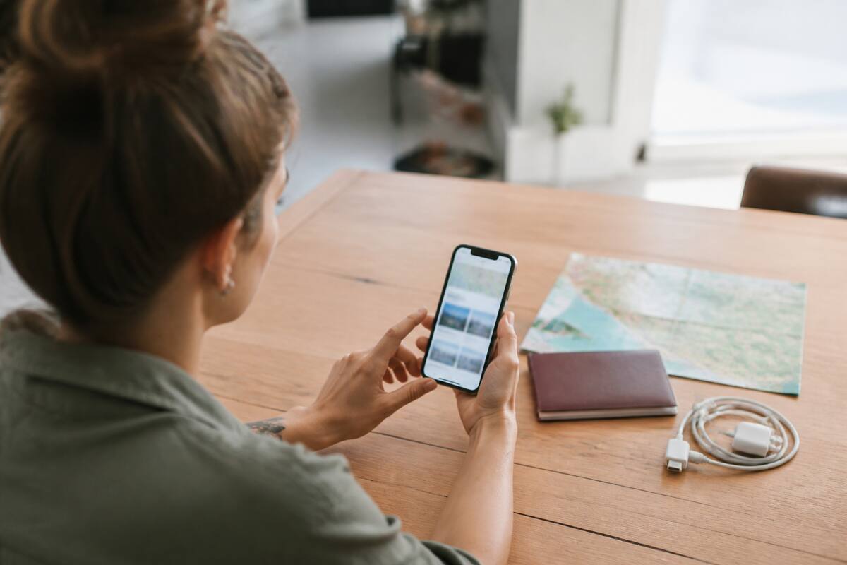 Reizen vergelijken op telefoon met paspoort en wereldkaart op tafel